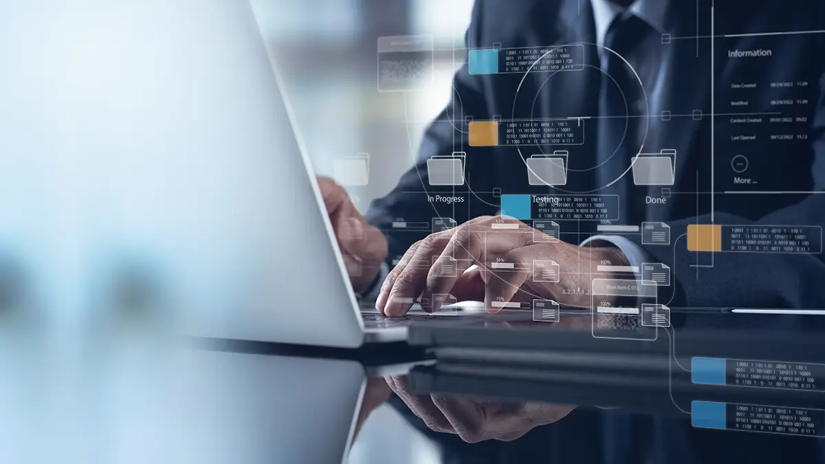 A man in a suit using a laptop, overlaid with a graphic of computer folders